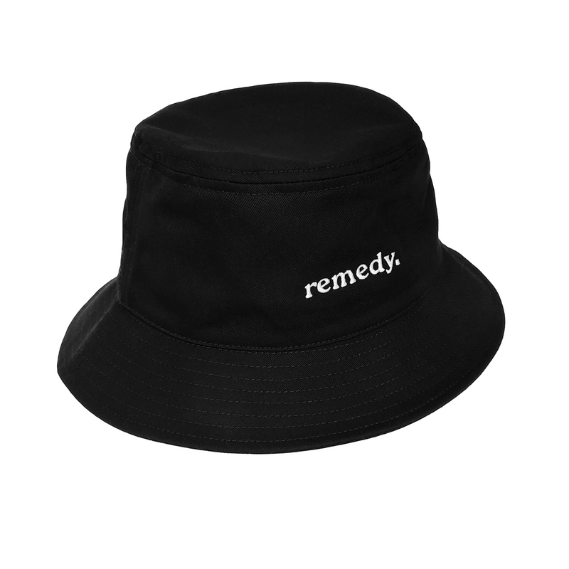 A side view of black bucket hat with white embroidery branded 'remedy' on the front.