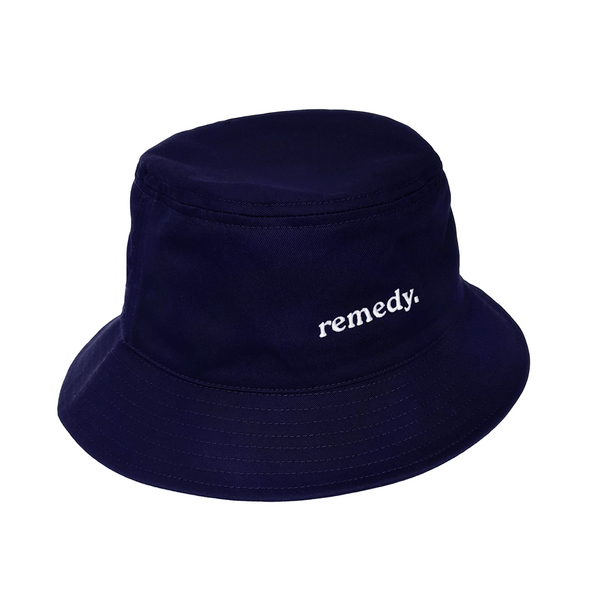 A side view of navy bucket hat with white embroidery branded  'remedy' on the front.